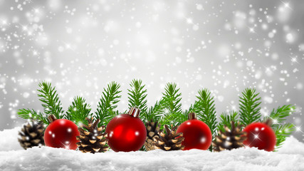 rote christbaumkugeln und tannengrün im schnee, weihnachtsdekoration in einer reihe vor unscharfen abstraktem hintergrund