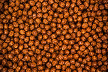 Chocolate breakfast cereal texture. Cereal balls as background. Chocolate corn balls