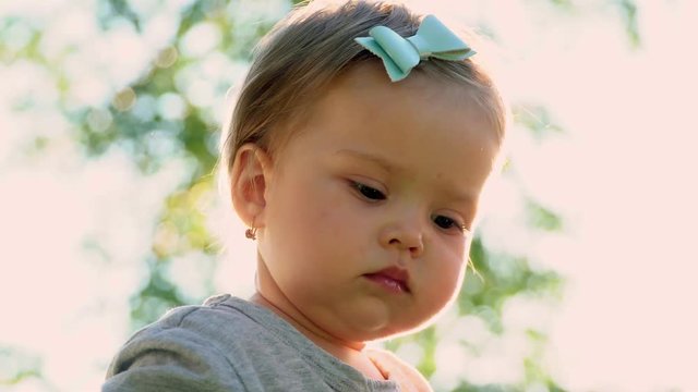 portrait of a little girl who looks closely. The action takes place in the open air. Girl brunette ms expressive look. Age 1,5 years.