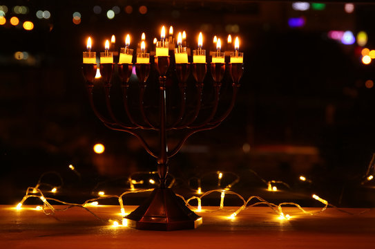image of jewish holiday Hanukkah background with menorah (traditional candelabra) and burning candles.