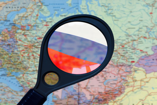 Flag of Russia closeup in a magnifier on a map of Europe