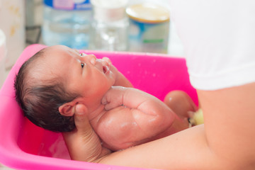 Obraz na płótnie Canvas baby bath on mother hand