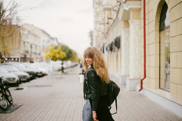 Portrait of a beautiful girl on the street, holding a paper cup