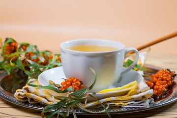 Tea made from sea buckthorn berries healthy for health delicious, saturated with vitamins surrounded by berries and sea buckthorn leaves for family tea drinking and maintaining health in the body