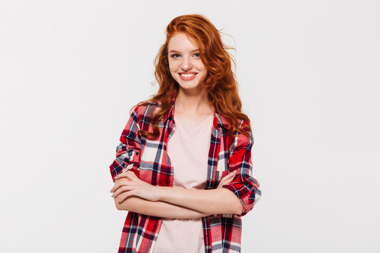 Happy attractive young redhead lady with arms crossed. Looking camera.