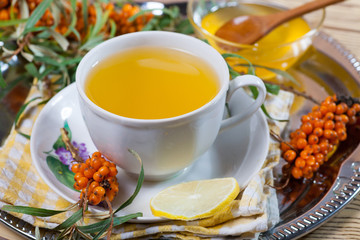 Tea made from sea buckthorn berries healthy for health delicious, saturated with vitamins surrounded by berries and sea buckthorn leaves for family tea drinking and maintaining health in the body