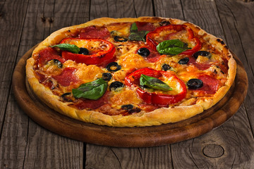Delicious pizza served on wooden plate