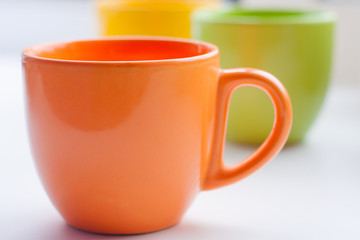 Group of colorful cups on bright background. Good morning mood after awakening concept.