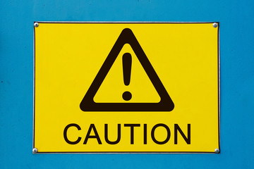 Closeup view of street caution exclamation sign on yellow metallic board