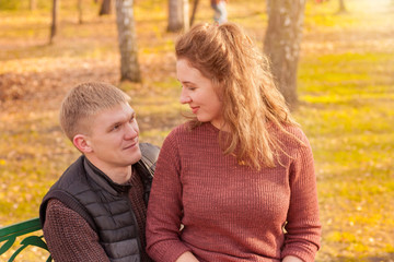 Fototapeta premium Young couple dating in autumn park looking into each other eyes. Love and romance concept.