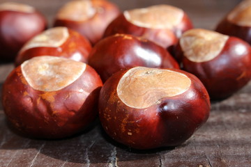 Chestnut on old wooden table close up with copy space. Top view. Autumn background, outdoor shoot.