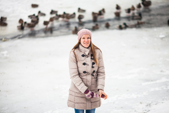 Girl feeding ducks in winter
