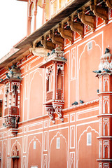Balconies with pigeons on Jaipur City Palace, Rajasthan, India. Maharaja Residence. Old Indian architecture with carving and ornament.