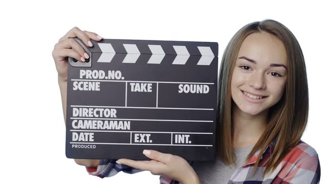 Smiling girl with clapperboard winking and clapping over white background