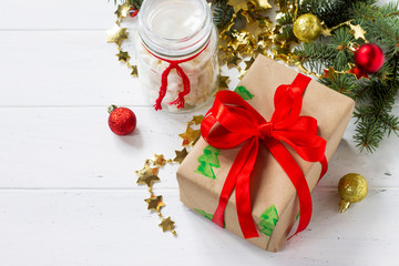 Christmas gift boxes and a jar of marshmallows with a Christmas tree on a white wooden table. Copy space.