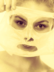 Woman removing facial peel off mask.