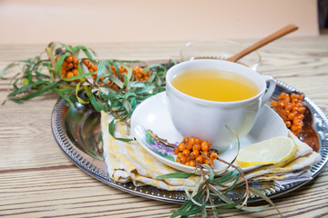 Tea made from sea buckthorn berries healthy for health delicious, saturated with vitamins surrounded by berries and sea buckthorn leaves for family tea drinking and maintaining health in the body
