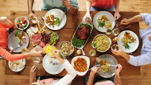 group of people eating at table with food