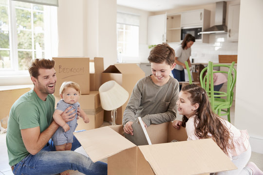 Children Helping Parents To Unpack On Moving In Day