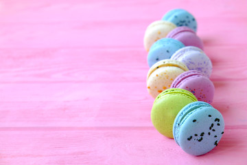 Tasty colorful macaroons in pink background. Text space. Pastel colors.