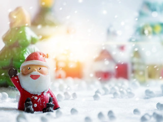 Cute happy Santa Claus dolls and Christmas props decorations on christmas snow field background with copy space.Merry Christmas and happy new year concept.