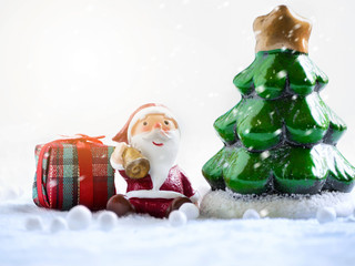 Cute happy Santa Claus dolls and Christmas props decorations on christmas snow field background with copy space.Merry Christmas and happy new year concept.