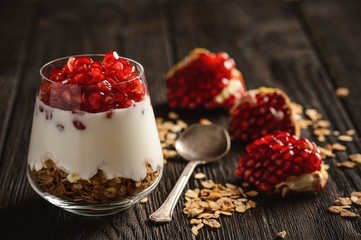 Healthy yogurt dessert with muesli and pomegranate.