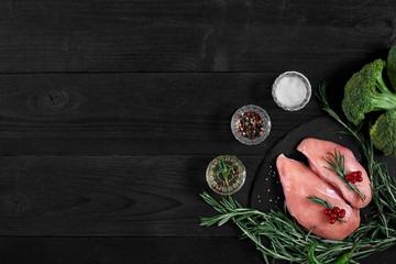 Cooking chicken breasts. On the table are spices - rosemary, red and black pepper. Concept - healthy food.