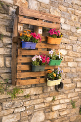Plant containers mounted against a pallet