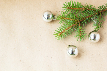 Fir tree branches decorated with silver christmas balls as border on a rustic holiday background frame with copy space