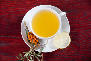 Tea made from sea buckthorn berries healthy for health delicious, saturated with vitamins surrounded by berries and sea buckthorn leaves and maintaining health in the body top view