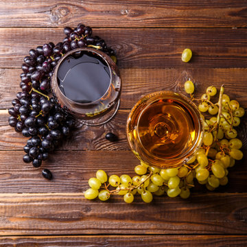 Image of two glasses with juice, grape, on wooden table,