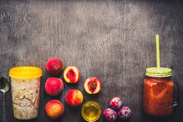 Useful peach fruit smoothie in glass bottle and straws and oatmeal with fruits, vegetarian breakfasts