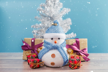 Happy snowman standing in blue winter christmas snow background. Merry christmas and happy new year greeting card with copy-space.