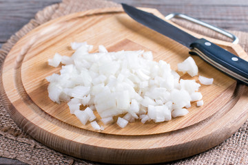 Raw onion, chopped very small cubes on a wooden board