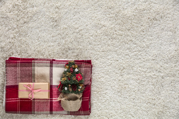 Photo taken from above. Wooden floor and bright carpet. Christmas decorations arranged evenly. Place your product or ad text or slogan.