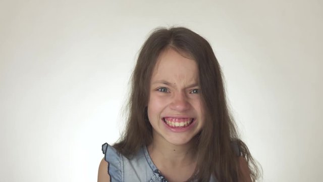 Beautiful sad teenage girl emotionally expresses anger close-up on white background stock footage video