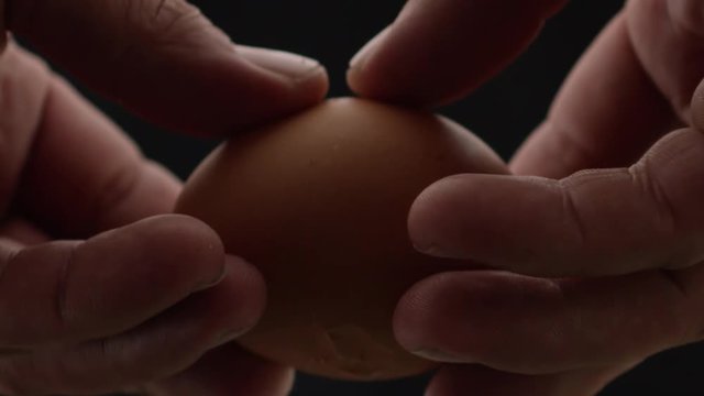 hands breaks the egg, yolk and protein flows out of the egg, frame close-up and slow-motion frame