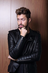 man fashion in leather jacket, wooden background