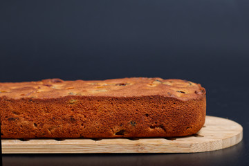 Food Homemade fruits cake loaf on wooden board with black background