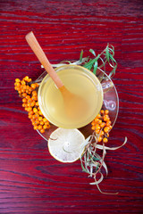 Tea made from sea buckthorn berries healthy for health delicious, saturated with vitamins surrounded by berries and sea buckthorn leaves and maintaining health in the body top view