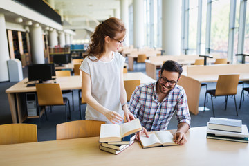 Obraz premium Young attractive students spending time in library