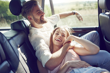 Happy young couple relaxing in car
