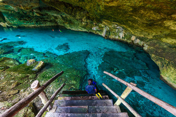 Obraz premium Cenote Dos Ojos in Quintana Roo, Mexico. People swimming and snorkeling in clear blue water. This cenote is located close to Tulum in Yucatan peninsula, Mexico.