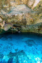 Cenote Dos Ojos in Quintana Roo, Mexico. People swimming and snorkeling in clear blue water. This cenote is located close to Tulum in Yucatan peninsula, Mexico.
