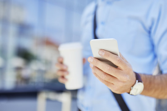 Close-up of businessman using smartphone outdoors