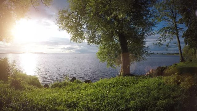 Calm and beautiful nature scene with sunset over lake in Sweden. Peaceful and idyllic summer landscape.