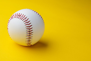 Baseball ball on yellow background with copy space