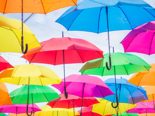Obraz na płótnie Canvas Multicolored umbrella pattern decorated with cloudy sky background.