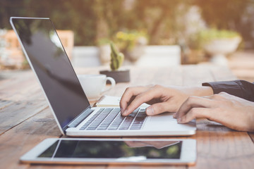 Businessman using laptop working with tablet and coffee.
